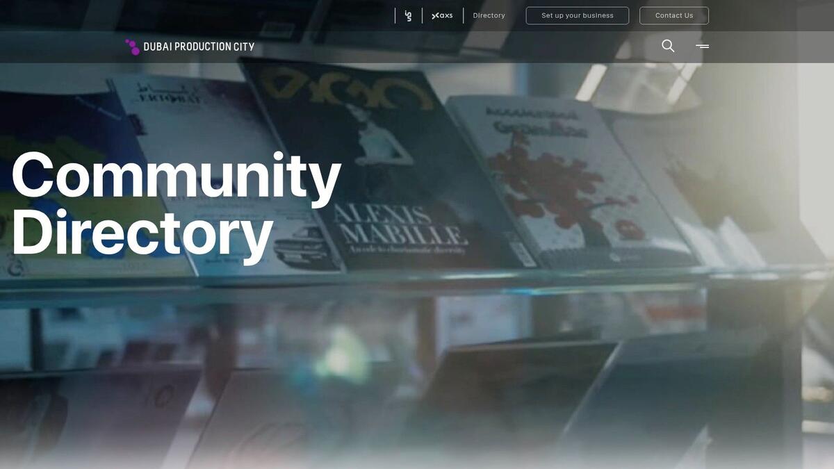 A screenshot of the Dubai Production City Community Directory website, showing business listings with contact details.